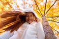 Happy young beautiful woman in autumn park on sunny day, Young woman in white coat during sunset in the park Royalty Free Stock Photo