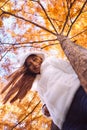 Happy young beautiful woman in autumn park on sunny day, Young woman in white coat during sunset in the park Royalty Free Stock Photo