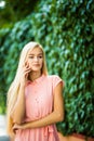 Happy young beautiful woman calling by phone in autumn on wall leaves green