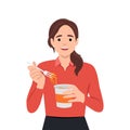 Happy young beautiful woman holding a bowl of noodles and eating hot and spicy instant noodles