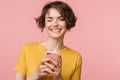 Happy young beautiful woman posing isolated over pink wall background using mobile phone Royalty Free Stock Photo