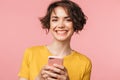 Happy young beautiful woman posing isolated over pink wall background using mobile phone Royalty Free Stock Photo