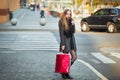 Happy young beautiful women holding shopping bags, walking away from shop on city street. Sale, consumerism and people Royalty Free Stock Photo