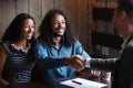 Happy young biracial couple clients and financial advisor shaking hands Royalty Free Stock Photo