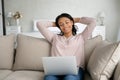 Happy African American woman relax on sofa with laptop Royalty Free Stock Photo