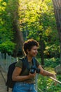 Happy young black African American female photojournalist with dark curly hair laughing happily looking at friend who has to