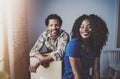 Happy young black african couple moving boxes into new apartment together and making a successful life.Cheerful family