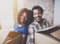 Happy young black african couple moving boxes into new home together and making a successful life.Cheerful family