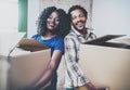 Happy young black african couple moving boxes into new house together and making a successful life.Cheerful family