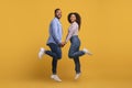 Happy young black couple holding hands and jumping in unison Royalty Free Stock Photo