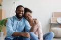 Happy young black couple hugging and showing keys to new apartment with cardboard boxes, looking at camera Royalty Free Stock Photo