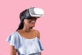 Happy young black lady wearing VR headset, exploring cyberspace, using virtual reality on pink background, copy space Royalty Free Stock Photo