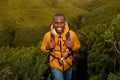 Happy young black man hiking in nature with backpack