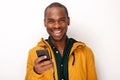 Happy young black man holding cellphone against isolated white background Royalty Free Stock Photo