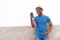 Happy young black man listening to music with mobile phone and earphones Royalty Free Stock Photo