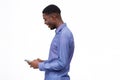 Happy young black man standing against isolated white background and looking at mobile phone Royalty Free Stock Photo