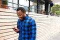 Happy young black man walking with cellphone in city Royalty Free Stock Photo