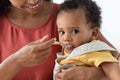 Happy Young Black Mother Spoon Feeding Her Cute Infant Baby Son, Closeup Royalty Free Stock Photo