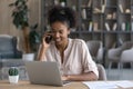 Happy young Black remote employee, worker talking on mobile phone