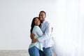 Happy young black spouses standing in their own house, hugging and smiling, being happy of buying own lodging Royalty Free Stock Photo