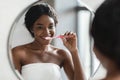 Young black woman with braces brushing her teeth Royalty Free Stock Photo