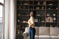 Happy young Black woman dancing in home interior, enjoying motion