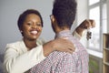 Happy young black woman hugging her husband, holding key to new house and smiling Royalty Free Stock Photo