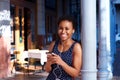 Happy young black woman listening to music with smart phone and earphones Royalty Free Stock Photo