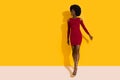 Happy Young Black Woman In Red Mini Dress And High Heels Is Walking Towards Camera And Looking Away Royalty Free Stock Photo