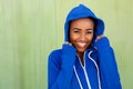 Happy young black woman smiling against green wall Royalty Free Stock Photo