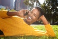 Happy young black woman smiling outdoors in park and talking with mobile phone Royalty Free Stock Photo
