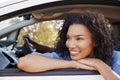 Happy young black woman looks out of a car window Royalty Free Stock Photo