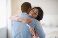 Happy young black woman with positive pregnancy test hugging her beloved husband indoors Royalty Free Stock Photo