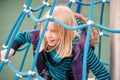 Happy young blonde girl playing on a rope ladder Royalty Free Stock Photo