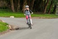 Happy young blonde girl riding her bike in a rural setting Royalty Free Stock Photo