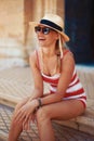 Happy young blonde mediterranean woman in sunglasses laughing