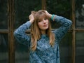 Happy young blonde woman with adorable smile enjoying early spring morning in city park posing outdoors with big window and Royalty Free Stock Photo