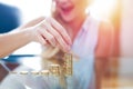 Happy young blonde woman building money column closeup