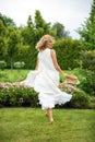 Happy young blonde woman walking barefoot on the green grass Royalty Free Stock Photo