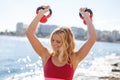 Happy young blonde woman workout with kettlebell outdoor