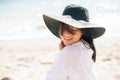 Happy young boho woman in hat relaxing and enjoying sunny warm day at ocean. Space for text. Stylish hipster girl sitting on beach Royalty Free Stock Photo