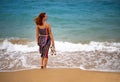 Happy young boho woman walking and having fun in the sea waves on a sunny warm day on a tropical island Royalty Free Stock Photo