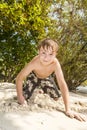 Happy young boy is digging in the sand of the beach Royalty Free Stock Photo