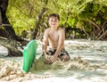 Happy young boy is digging in the sand of the beach Royalty Free Stock Photo