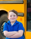 Happy young boy in front of school bus Royalty Free Stock Photo