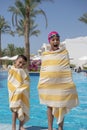 Happy Young Kids Covered with Towels at Swimming Pool