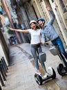 Positive boy and girl posing on segways in vacation