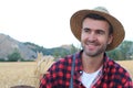 Happy young boy in hat walking on wheat summer field. Harvest concept