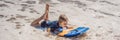 Happy Young boy having fun at the beach on vacation, with Boogie board BANNER, LONG FORMAT Royalty Free Stock Photo