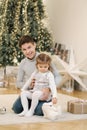 Happy young boy with his niece play in front of fir tree. Christmas mood Royalty Free Stock Photo